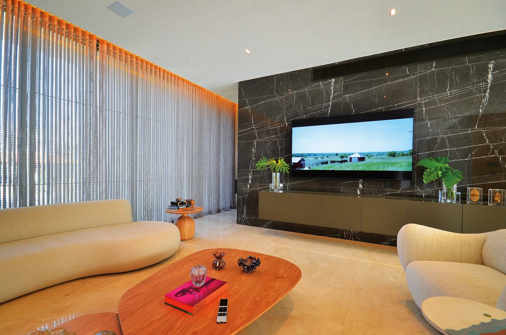 Sala de alto padrão com automação integrada — iluminação, som e TV controlados pelo mesmo sistema