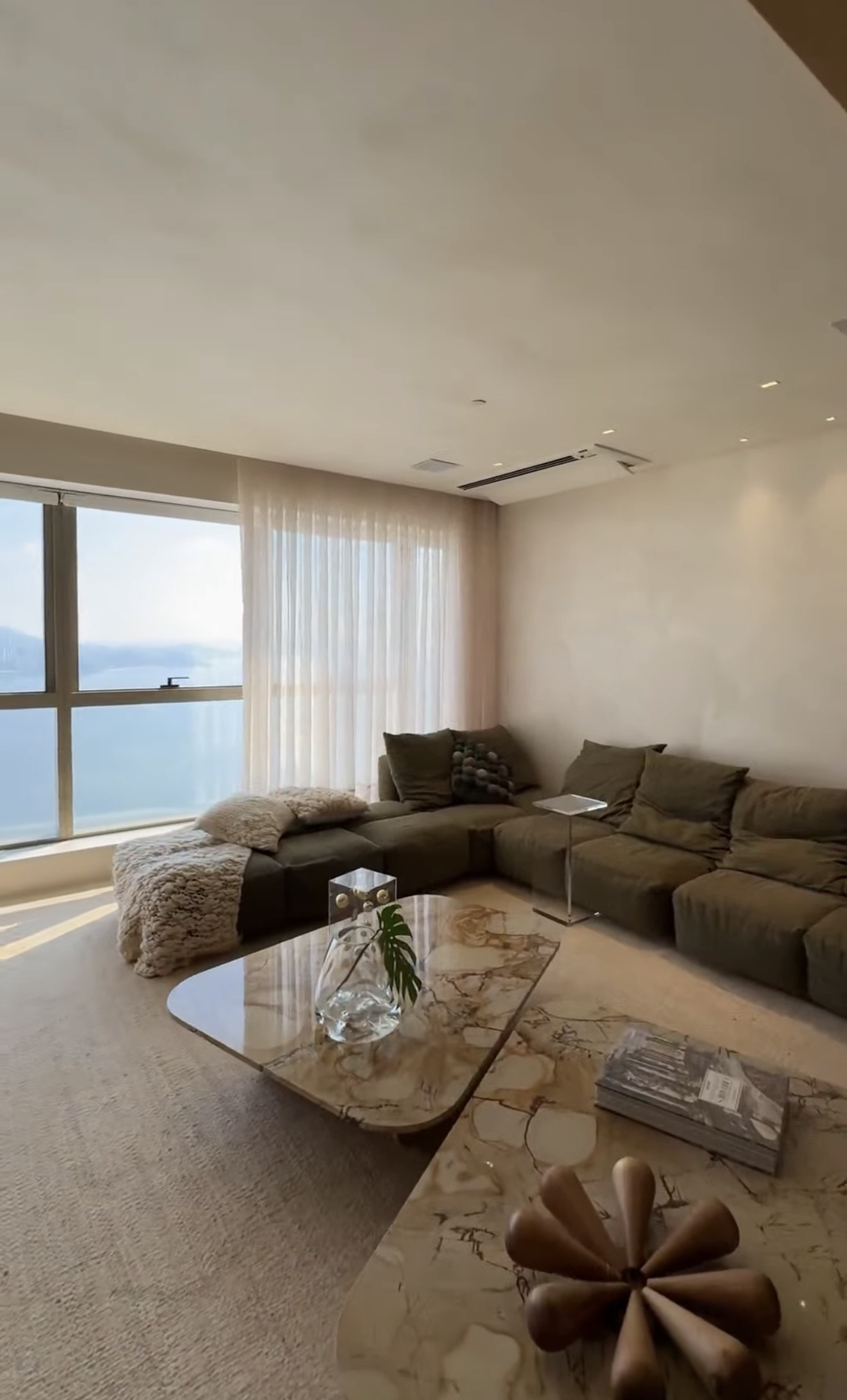 Living integrado do Yacht House com sofá, mesa de centro em mármore e vista panorâmica para o mar