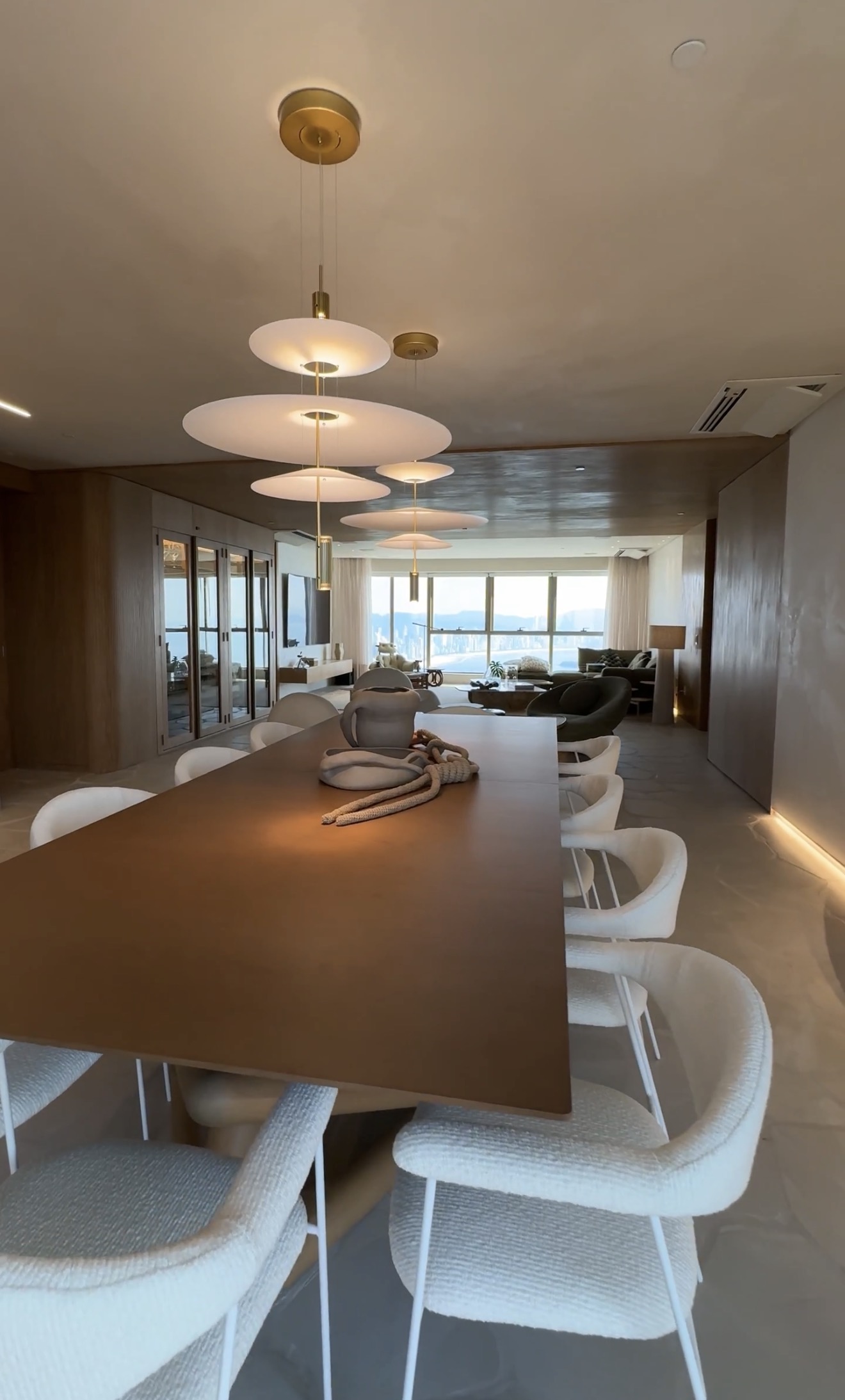 Sala de jantar do Yacht House integrada ao living, com iluminação cênica e vista para o mar